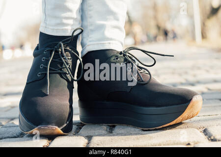 Woman's Beine in schwarzen Schuhen auf flachen Plattform auf Street, close-up Stockfoto