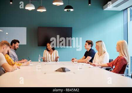 Geschäftsfrau Adressierung Gruppe von Kandidaten treffen um den Tisch der Graduate Recruitment Assessment Day Stockfoto