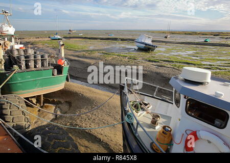 Bunte Fischtrawler festgemacht am Kai mit dem schlammigen Strand bei Ebbe im Hintergrund, Leigh-on-Sea, Großbritannien Stockfoto