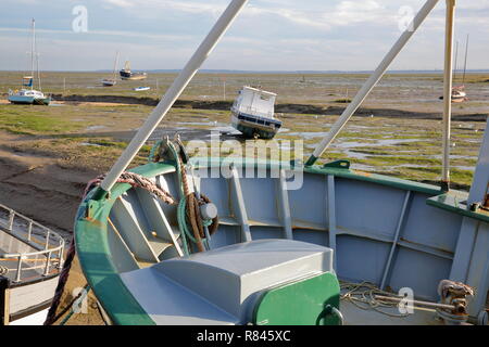 Bunte Fischtrawler festgemacht am Kai mit dem schlammigen Strand bei Ebbe im Hintergrund, Leigh-on-Sea, Großbritannien Stockfoto