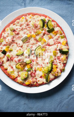 Rote-bete-base Pizza mit Zucchini, geräucherter Schinken, Käse & rote Zwiebel Stockfoto