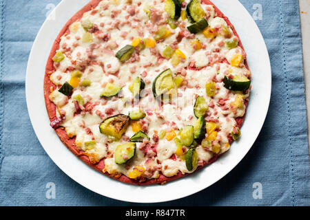 Rote-bete-base Pizza mit Zucchini, geräucherter Schinken, Käse & rote Zwiebel Stockfoto