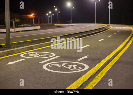 Fahrrad Fahrbahnmarkierungen und Schilder. Beleuchtete Rad weg reisen Lane reserviert für Radfahrer mit Fahrbahnmarkierungen mit Pfeilen, die direkte Radfahrer Stockfoto