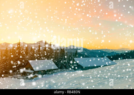 Alte Holz- Haus, Hütte und Stall, Haufen von Brennholz in tiefem Schnee auf dem Berg Tal, Fichtenwald, bewaldeten Hügeln auf klare, blaue bunte Himmel bei Sonnenaufgang cop Stockfoto