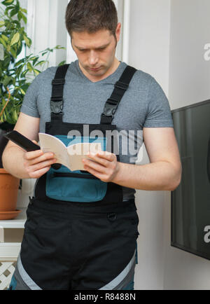 Männliche Techniker Einrichten neuer TV mit der Anweisung. Stockfoto