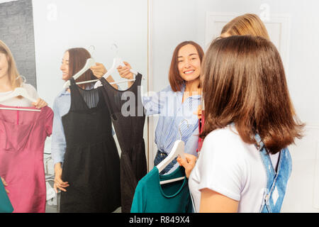 Mutter versuchte, Kleid für unsere Tochter im Teenageralter zu wählen Stockfoto