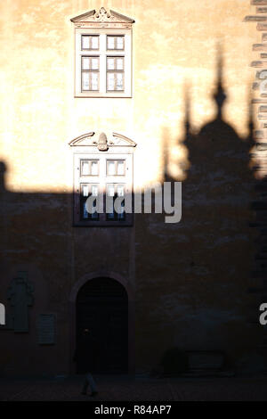 Aschaffenburg, Deutschland - November 17, 2018: ein Besucher von Schloss Johannisburg Spaziergänge durch die Schatten der Burg Türme im Innenhof auf Novembe Stockfoto