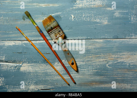 Schmutzige Pinsel auf Blau Holztisch - Nahaufnahme Stockfoto