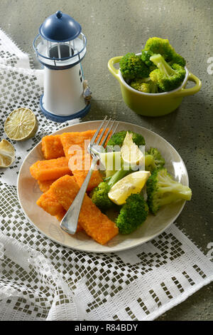 Fischstäbchen mit Brokkoli und Zitrone garnieren - Nahaufnahme Stockfoto