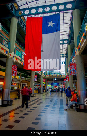 SANTIAGO, CHILE - Oktober 09, 2018: Unbekannter Menschen innerhalb der Busbahnhof an mit chilenischer Flagge hängen von der Dachterrasse wartet. Dies ist die grösste und wichtigste Busbahnhof der Stadt Stockfoto