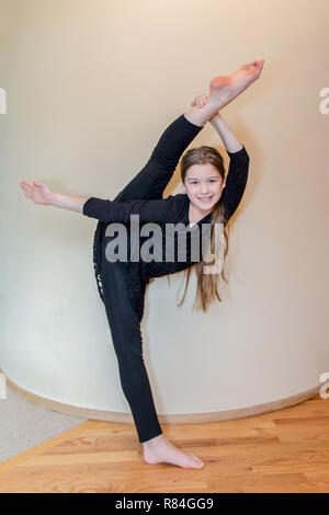 Zehn Jahre alten Tänzerin Mädchen ihre Flexibilität zeigen, indem Sie mit Pfeil und Bogen Bein halten. (MR) Stockfoto