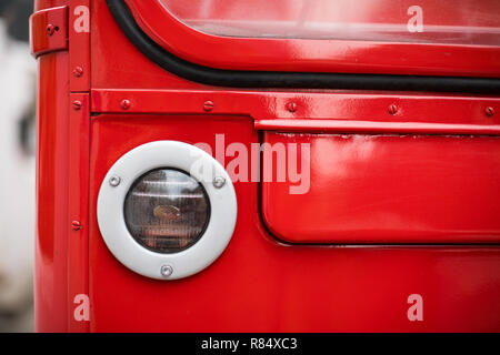 Detail eines roten Doppeldeckerbus Scheinwerfer. Stockfoto