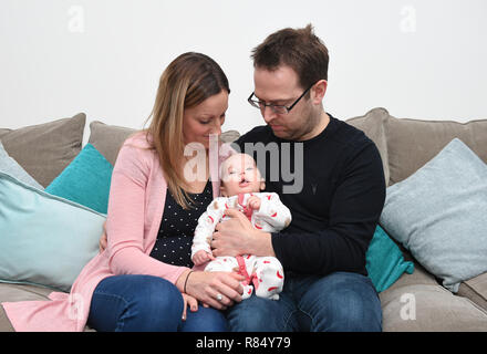 Emily James und Ehemann Chris James mit Ihrem zwei Monate alten Sohnes Harvey an ihrem Haus in Upper Cambourne, Cambridgeshire. Stockfoto