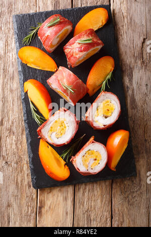 Gebackene roll Schweinefilet gefüllt mit Dattel und Käse in Prosciutto enger gewickelt - auf den Tisch. Vertikal oben Ansicht von oben Stockfoto