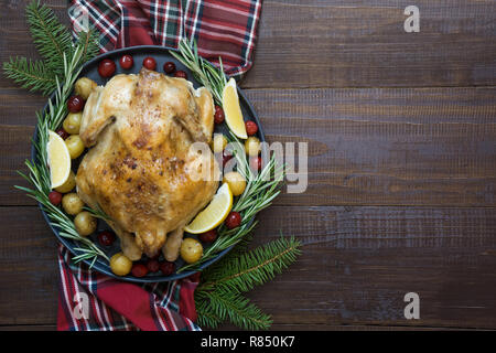 Traditionelle Weihnachten Hähnchen mit Gewürzen und Rosmarin auf Holztisch. Ansicht von oben. Stockfoto