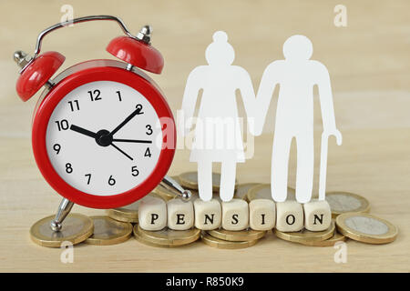 Das Wort Rente mit hölzernen Blöcke geschrieben, Papier ältere Paare und Wecker auf Münzen - Pension zeit Konzept Stockfoto