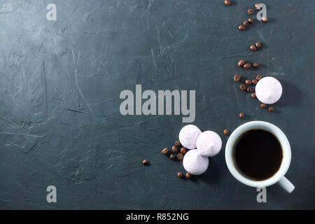 Morgen aromatischen Kaffee mit gebackenen Baiser, auf schwarzem Beton. Blick von oben. kopieren. Stockfoto