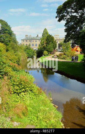 Touristen entspannen durch den Fluss im Buxton Pavilion Gardens Stockfoto