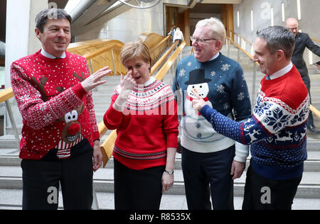 (Von links) Presiding Officer Ken Macintosh, Erster Minister Nicola Stör, der stellvertretende Vorsitzende der Schottischen Konservativen Carlaw Jackson, und Schottische liberaler Demokrat Alex Cole-Hamilton verschleiß Weihnachten Jumper für die Save the Children Charity am schottischen Parlament in Edinburgh. Stockfoto