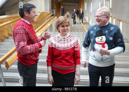 (Von links) Presiding Officer Ken Macintosh, Erster Minister Nicola Sturgeon und Schottischen Konservativen stellvertretende Carlaw Jackson, Verschleiß Weihnachten Jumper für die Save the Children Charity am schottischen Parlament in Edinburgh. Stockfoto