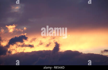 Landschaft mit schönen lila Sonnenuntergang mit bunten surreale dunkle Wolken auf feurigen Himmel am Abend Panoramaaussicht Stockfoto