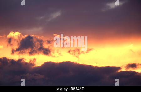 Landschaft mit schönen lila Sonnenuntergang mit bunten surreale dunkle Wolken auf feurigen Himmel am Abend Panoramaaussicht Stockfoto