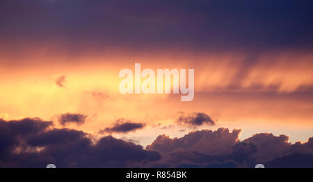 Landschaft mit schönen lila Sonnenuntergang mit bunten surreale dunkle Wolken auf feurigen Himmel am Abend Panoramaaussicht Stockfoto