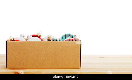 Karton mit bunten Glas Weihnachten Kugeln auf hölzernen Tisch gegen den weißen Hintergrund. Copyspace. Stockfoto