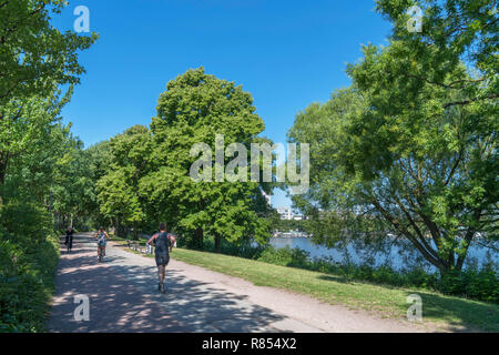 Läufer und Radfahrer auf dem Weg entlang der Außenalster (Außenalster), ein künstlicher See in Hamburg, Deutschland Stockfoto