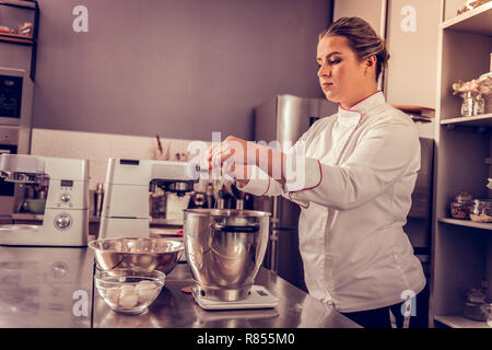 Besten Kuchen. Qualifizierten professionellen Koch das Mischen der Zutaten, einen biskuitboden Stockfoto