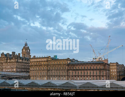 Edinburgh großen Gebäuden im Winter Dawn. Rocco Forte Hotel Balmoral mit Uhrturm und der Waverley Station Glasdach, Schottland, Großbritannien Stockfoto