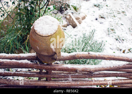 Alte kaputte Ton Kanne auf Zaun im Winter Stockfoto