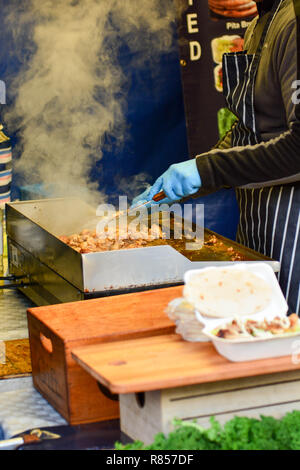 Street Food vendor kochen Stücke Huhn auf tragbaren Warmhalteplatte an den lokalen Markt Stockfoto