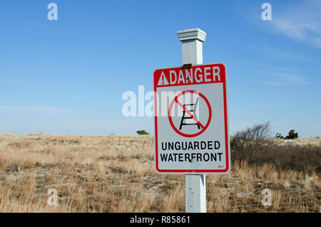 Gefahr unbewachten waterfront Zeichen auf Holz Pfosten durch Dünen bei Scusset Beach, Cape Cod im Sagamore, Bourne, Massachusetts, USA Stockfoto