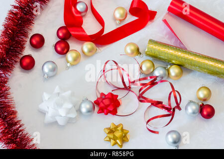 Bunte Papier für die Verpackung Weihnachtsgeschenke mit Band Kugeln und Lametta Stockfoto