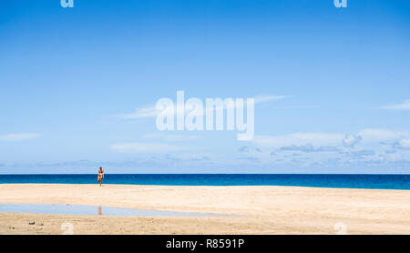 Eine Frau im Bikini, Wandern auf Hanakapi'ai Strand entlang der Na Pali Küste von Kauai, Hawaii, USA. Stockfoto