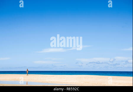 Eine Frau im Bikini, Wandern auf Hanakapi'ai Strand entlang der Na Pali Küste von Kauai, Hawaii, USA. Stockfoto