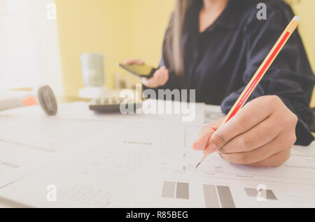 Business Konzept der Finanz- und Rechnungswesen mit der menschlichen Hand halten Smartphone und Schreiben, Finanzen Bericht und mit Blatt Papier von Planungsdaten Stockfoto