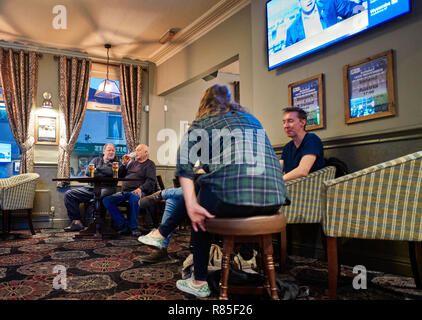 Watching Sport an einem Samstag Nachmittag in einem Pub mit TV-Bildschirme und gemusterten Teppich Stockfoto