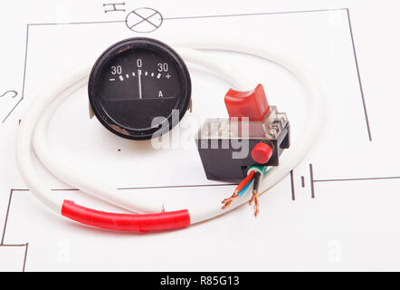 Amperemeter und rote Starttaste auf dem Hintergrund des elektrischen Systems Stockfoto