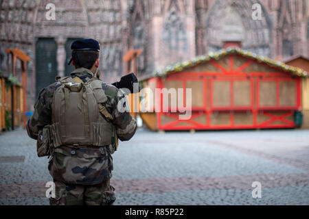 Straßburg, Frankreich. 13. Dez 2018. 13. Dezember 2018 Frankreich (Frankreich), Straßburg: ein französischer Soldat an Weihnachten Marktstände geschlossen nach einem Angriff in der Nähe des Straßburger Weihnachtsmarkt vor dem Dom. Ein Attentäter hatte zwei Menschen in der Nähe des Weihnachtsmarkts Schuß auf 12.12.2018. Der 29-Jährige ist noch auf der Flucht. Die Anti-terror-Spezialisten des Büros des Pariser Staatsanwaltschaft die Ermittlungen übernommen haben. Foto: Sebastian Gollnow/dpa Quelle: dpa Picture alliance/Alamy leben Nachrichten Stockfoto