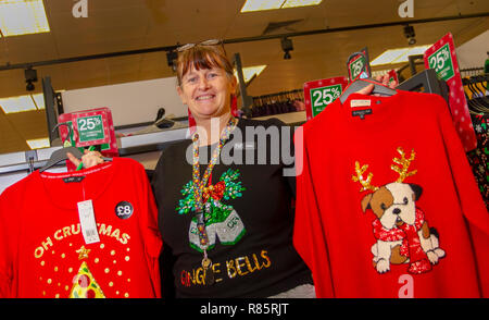 Southport, Merseyside, UK. 13 Dez, 2018. Pauline Holms (MR) zeigt Weihnachtsstimmung bei Tesco als Mitarbeiter im festlichen Spaß verbinden. Tesco Mitarbeiter in den Weihnachten festliche Stimmung durch die Unterstützung von Speichern Weihnachten jumper Tag der Kinder. Personal vereinbart einfach auf einem albernen Pullover Stick und fördern Spenden zu helfen, das Leben von Kindern retten. Freitag zum siebten jährlichen Weihnachten Jumper Tag der Mittelbeschaffung für Nächstenliebe in der kammgarn sartorial Ereignis des Jahres, Kredit: MediaWorldImages/AlamyLiveNews. Stockfoto