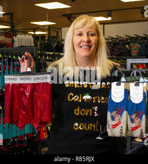 Southport, Merseyside, UK. 13 Dez, 2018. Jeanette Waind (MR) zeigt den Geist von Weihnachten zu Weihnachten Geist bei Tesco als Mitarbeiter im festlichen Spaß verbinden. Tesco Mitarbeiter in den Weihnachten festliche Stimmung durch die Unterstützung von Speichern Weihnachten jumper Tag der Kinder. Personal vereinbart einfach auf einem albernen Pullover Stick und fördern Spenden zu helfen, das Leben von Kindern retten. Freitag zum siebten jährlichen Weihnachten Jumper Tag der Mittelbeschaffung für Nächstenliebe in der kammgarn sartorial Ereignis des Jahres, Kredit: MediaWorldImages/AlamyLiveNews. Stockfoto