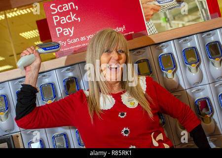 Southport, Merseyside, UK. 13 Dez, 2018. Wendy Meath (MR) zeigt Weihnachtsstimmung bei Tesco als Mitarbeiter im festlichen Spaß verbinden. Tesco Mitarbeiter in den Weihnachten festliche Stimmung durch die Unterstützung von Speichern Weihnachten jumper Tag der Kinder. Personal vereinbart einfach auf einem albernen Pullover Stick und fördern Spenden zu helfen, das Leben von Kindern retten. Freitag zum siebten jährlichen Weihnachten Jumper Tag der Mittelbeschaffung für Nächstenliebe in der kammgarn sartorial Ereignis des Jahres, Kredit: MediaWorldImages/AlamyLiveNews. Stockfoto