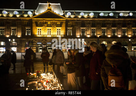 Straßburg, Frankreich. 12 Dez, 2018. Trauernde sind neben Kerzen in Gedenken an die Opfer des Anschlags auf dem Weihnachtsmarkt in Straßburg beleuchtet. Trauernde versammelten sich in der Nähe des Straßburger Weihnachtsmarkt, wo Kerzen in Gedenken an die Opfer entzündet worden war. Die Ermittler gehen davon aus, dass die tödlichen Angriff in der vergangenen Nacht war ein Akt des Terrorismus. Anti-terror-Spezialisten des Büros des Pariser Staatsanwaltschaft haben sich im Laufe der Untersuchung berücksichtigt. Credit: Elyxandro Cegarra/SOPA Images/ZUMA Draht/Alamy leben Nachrichten Stockfoto