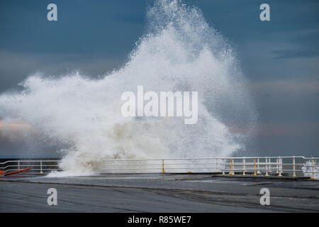 Aberystwyth, Wales. 13. Dez 2018. UK Wetter: Strong gale force Winden und eine Flut kombinieren riesige Wellen gegen das Meer Abwehr in Aberystwyth auf der Cardigan Bay Küste von West Wales zu hämmern. Ein bitter kalt easterly Wind mit Böen bis 36 km/h und eine Frost ist über Nacht, da der Himmel klar Foto Keith Morris/Alamy Leben Nachrichten Prognose Stockfoto