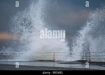 Aberystwyth, Wales. 13. Dez 2018. UK Wetter: Strong gale force Winden und eine Flut kombinieren riesige Wellen gegen das Meer Abwehr in Aberystwyth auf der Cardigan Bay Küste von West Wales zu hämmern. Ein bitter kalt easterly Wind mit Böen bis 36 km/h und eine Frost ist über Nacht, da der Himmel klar Foto Keith Morris/Alamy Leben Nachrichten Prognose Stockfoto