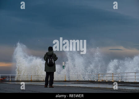 Aberystwyth, Wales. 13. Dez 2018. UK Wetter: Strong gale force Winden und eine Flut kombinieren riesige Wellen gegen das Meer Abwehr in Aberystwyth auf der Cardigan Bay Küste von West Wales zu hämmern. Ein bitter kalt easterly Wind mit Böen bis 36 km/h und eine Frost ist über Nacht, da der Himmel klar Foto Keith Morris/Alamy Leben Nachrichten Prognose Stockfoto