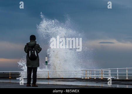 Aberystwyth, Wales. 13. Dez 2018. UK Wetter: Strong gale force Winden und eine Flut kombinieren riesige Wellen gegen das Meer Abwehr in Aberystwyth auf der Cardigan Bay Küste von West Wales zu hämmern. Ein bitter kalt easterly Wind mit Böen bis 36 km/h und eine Frost ist über Nacht, da der Himmel klar Foto Keith Morris/Alamy Leben Nachrichten Prognose Stockfoto