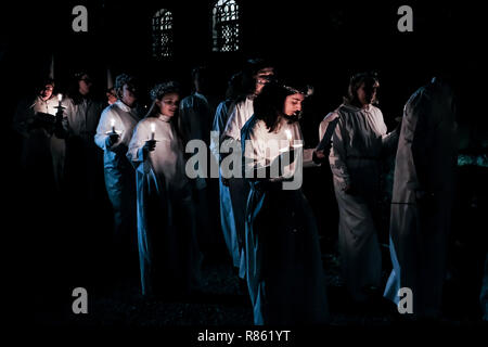 Jerusalem, Israel. 13. Dezember, 2018. Die schwedische Theologisches Institut (STI) in Jerusalem hosts Santa Lucia Tag Feiern zum Gedenken an Lucia von Syrakus (283-304), Saint Lucia, Saint Lucia, oder Sancta Lucia. Das Fest ist ein Fest des Lichts gefeiert, vor allem in skandinavischen Ländern, wo junge Mädchen traditionell in weiß mit einem roten Schärpe gekleidet werden, Palmen und tragen Kränze von Kerzen auf dem Kopf. Credit: Nir Alon/Alamy leben Nachrichten Stockfoto